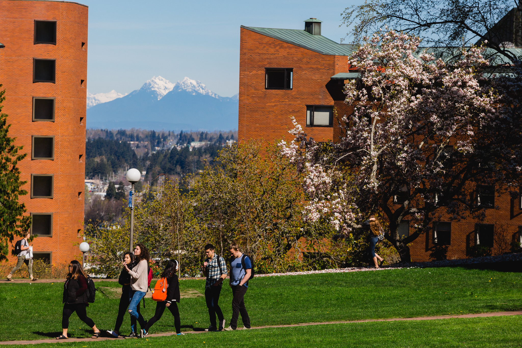 Students walking in front of Nash and Mathes Halls with snow-capped mountains in the background