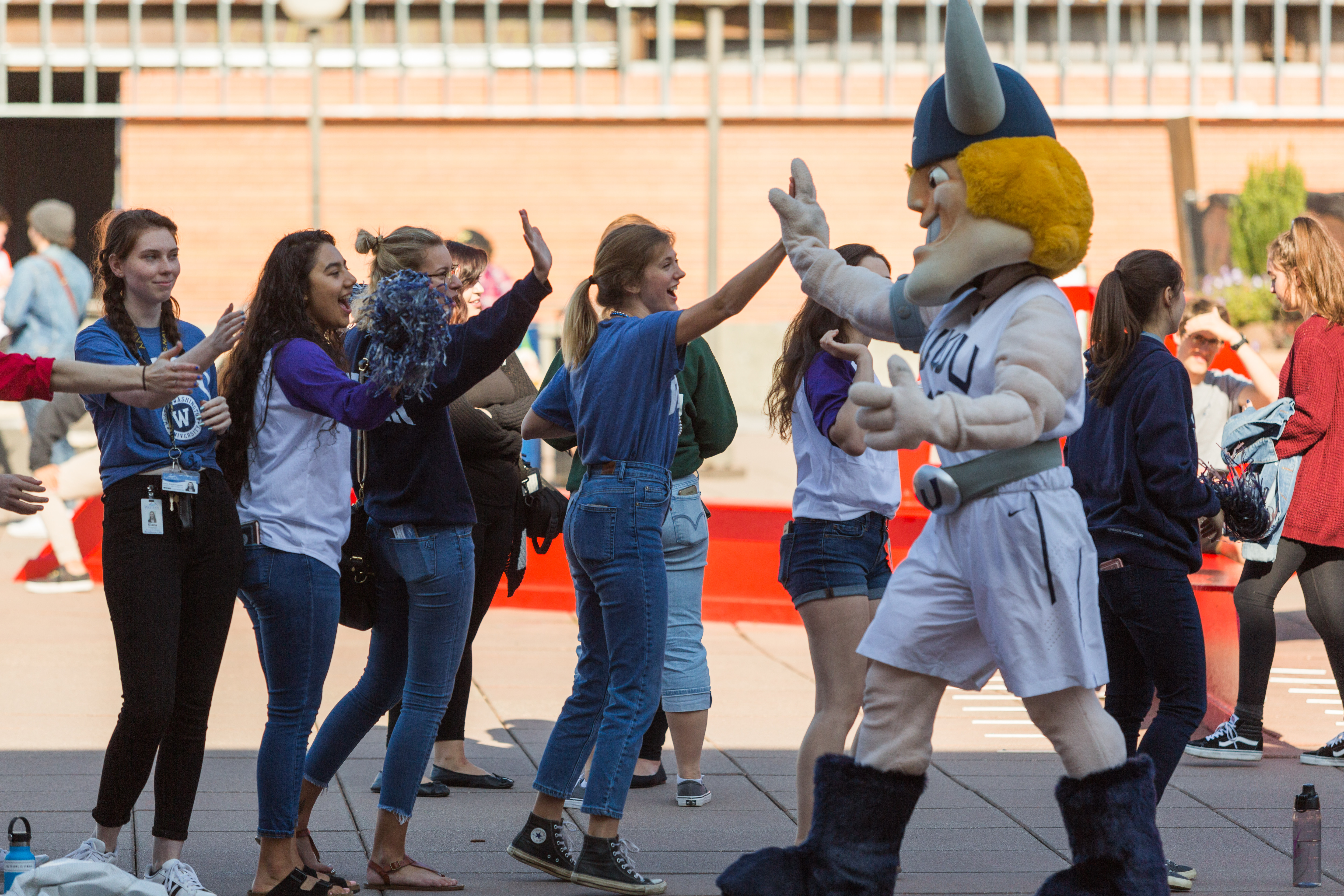 A line of students giving high-fives to WWU's mascot Victor Viking