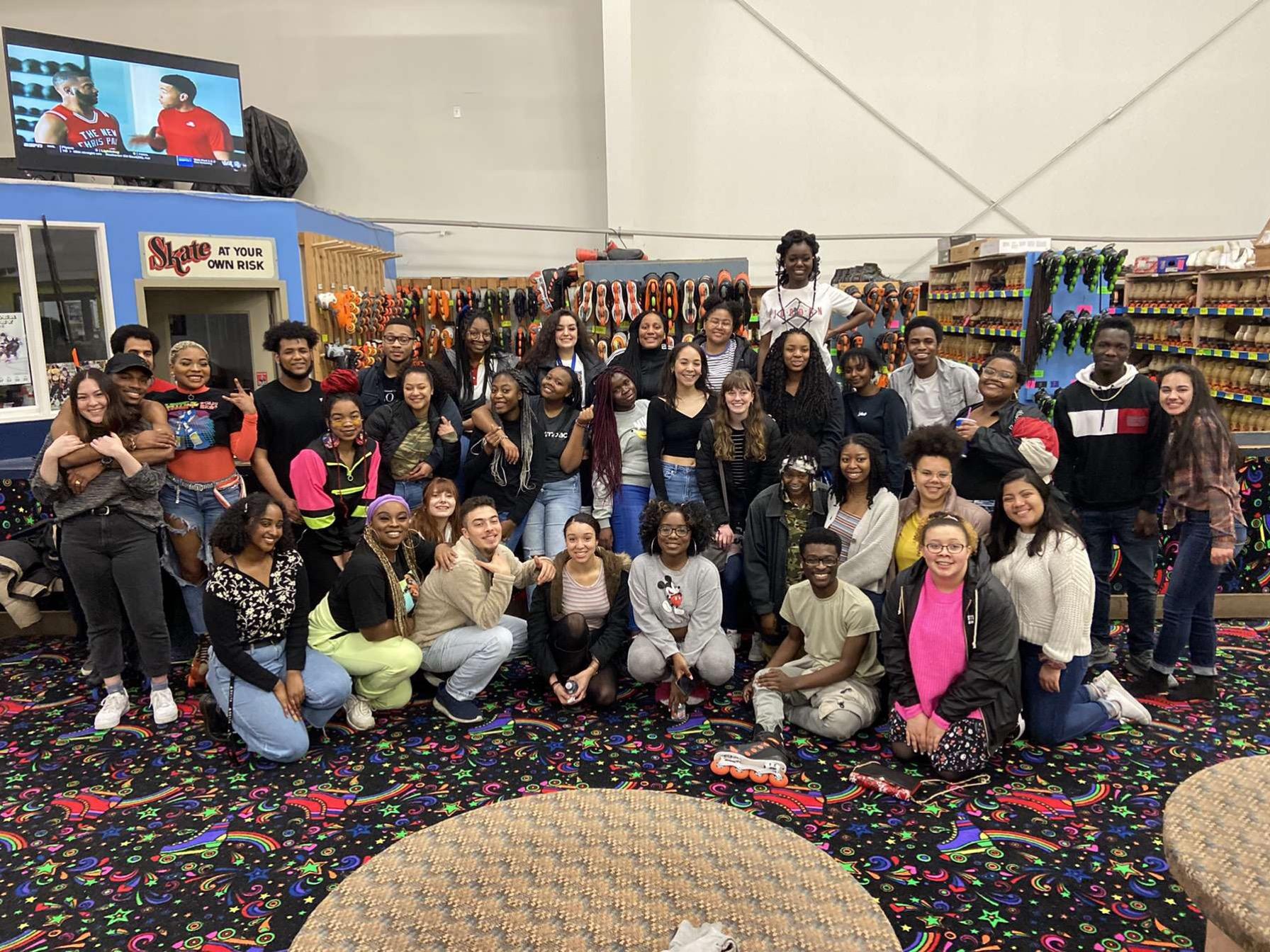 Students from The Black Student Coalition posing and smiling together at a skate rink.