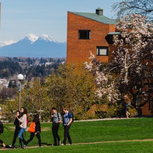 Students walking in front of Nash and Mathes Halls with snow-capped mountains in the background